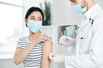 a doctor injects a vaccine to a female patient covid 