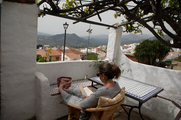 A woman is sitting and reading a book