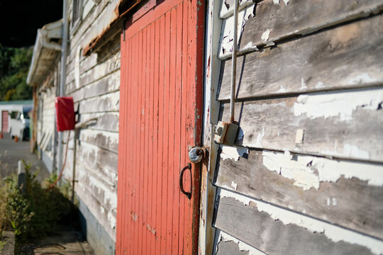 Delapidated building with red door needs some repair