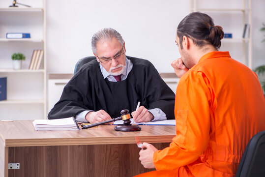 Old male judge meeting with young captive in courthouse