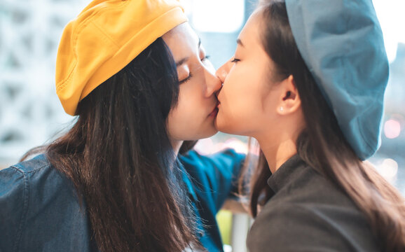 LGBT, portrait of lesbian couple Asian women using lips kissing outdoor city.Two girls lesbian couple hugging , close up portrait.
