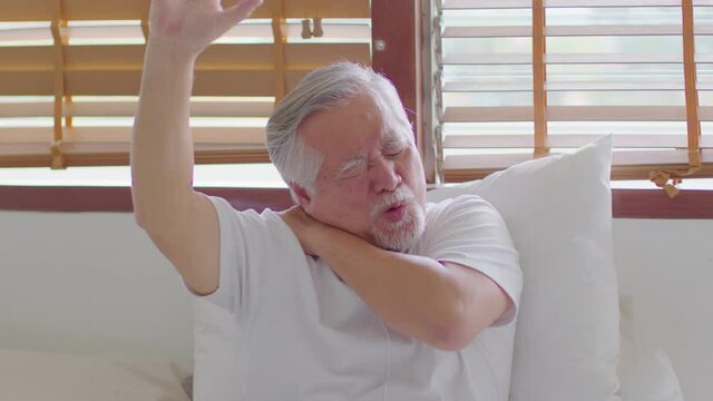 Asian Elderly senior man with white hairs neck and shoulder pain and injury muscle upper back problem illness after wake up on bed at home,Elder Care Concept