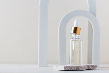 Serum or oil for facial skin care. Cosmetic care product in a glass shade on the background of arches. Copy space.