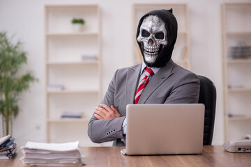 Devil businessman employee sitting at workplace