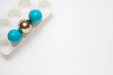 Simple minimalistic Easter greeting card with three blue and golden Easter eggs in plastic stand hold