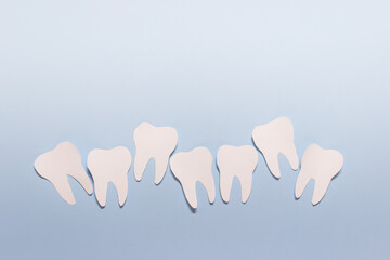 Paper stomatology oral health composition with uneven row of teeth on blue background