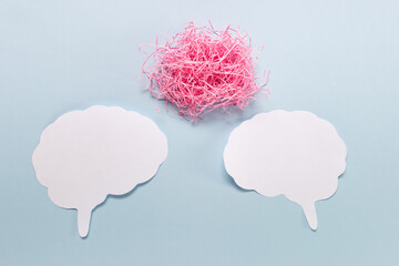 Mind brain communication thinking argument concept with two paper brains and pink cloud on blue...