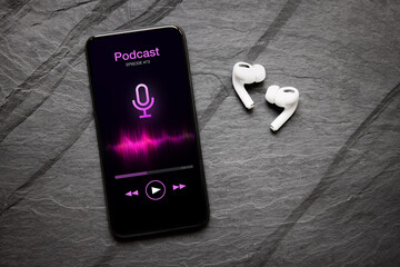 Wireless earbuds and mobile phone with podcast app on the screen