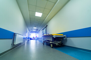 Empty gurney in new modern hospital. Low angle view on empty corridor in clinic. Closeup.