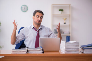 Young businessman and too much work in the office