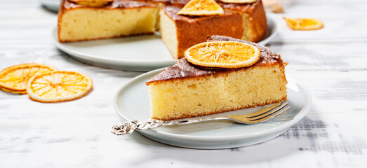 Slice of Semolina cake decorated with dried orange slices.	 - Powered by Adobe