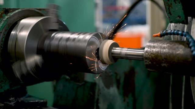 Grinding the end face of the part with an abrasive stone with sparks on a circular grinding machine.