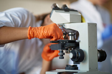 A young female student adjusts a microscope in a laboratory. Science, chemistry, lab, people