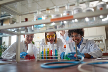 Young chemistry students in a laboratory love working with colorful chemical. Science, chemistry,...