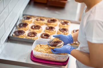 A worker making delicious donuts in a candy workshop. Pastry, dessert, sweet, making