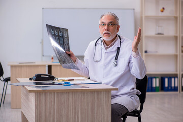 Old male doctor radiologist working in the clinic