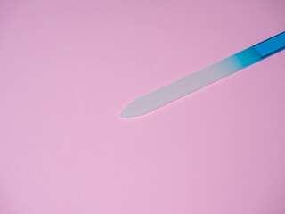 nail file in blue on a pink background. An accessory for the beauty and care of the nails of the hands and feet. Copy space