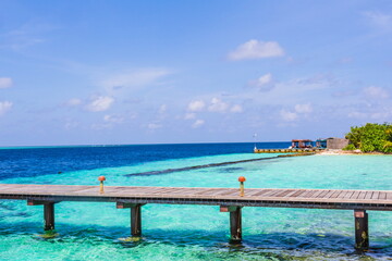 Fototapeta na wymiar Wooden pier on a tropical beach in the Maldives