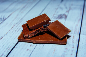 pieces of chocolate on a wooden table, chocolate, sweet, food, dessert, brown, dark, isolated,...