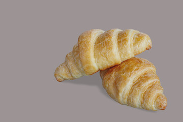 Two croissants are stacked, the background isolate