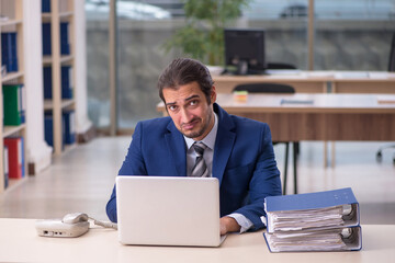 Fototapeta premium Young male employee working in the office