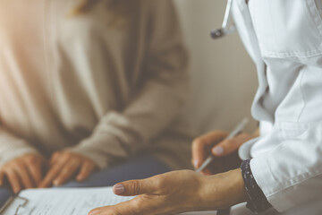 Fototapeta premium Close-up of woman-doctor and patient discussing current health examination while sitting indoors. Stay at home concept during Coronavirus pandemic and self isolation quarantine. Covid 2019
