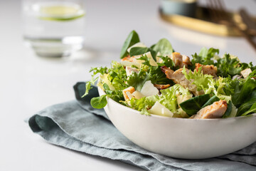 Cesar salad plate served on restaurant table.  Healthy salad with different  lettuce, chicken,...