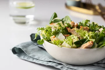 Foto op Aluminium Cesar salad plate served on restaurant table.  Healthy salad with different  lettuce, chicken, parmesan cheese and croutons. © vasanty