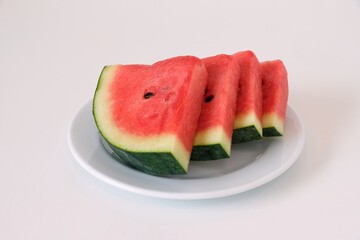 Watermelon slices in a white plate on white background