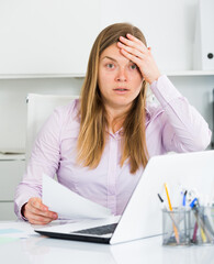 Young female worker having problem in project in office