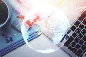 Business theme hologram drawings over computer on the desktop background. Top view. Multi exposure....