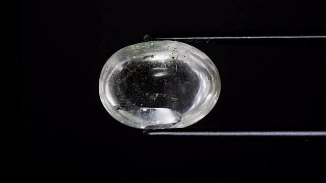 natural moss quartz gemstone in tweezer on the turning table