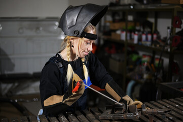 Portrait of cute caucasian girl blonde welder working in the garage