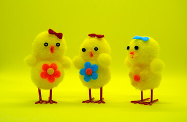 Three decorative yellow chicken on a yellow background.