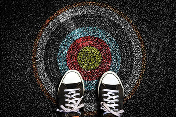 Target on the road. Sneakers on asphalt road. Top view. The concept of hitting the target. Succes....