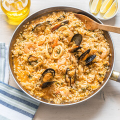 Risotto with seafood - squid, shrimps and mussels in a pan, close-up, top view