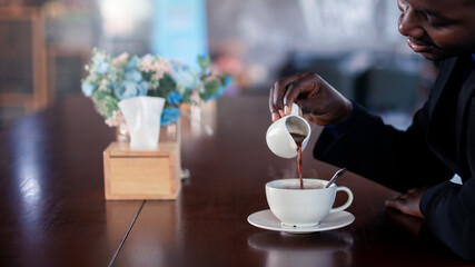 African businessman making hot coffee with smile and happy