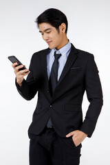 Portrait shot of Asian young black short hair executive lawyer manager in formal suit with necktie standing smiling look at mobile smartphone in hand checking message in front of white background