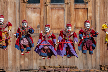 Colorful puppets in a tourist stall on the street market in Burma, Myanmar. Handmade dolls hanging...