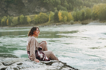 Young woman traveller in casual with backpack on mountain river on sunset