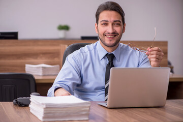 Young male employee and too much work in the office