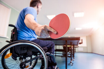 Adult disabled men in a wheelchair playing table tennis