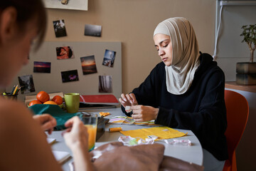 Woman wearing hijab relaxing with the sewing while spending time with her best friend