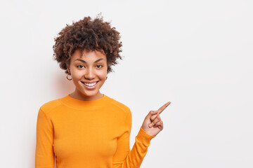 Beautiful curly haired Afro American woman suggests to clickon link points on blank copy space...