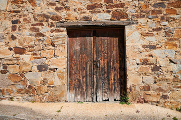 Old wooden door in the stone wall