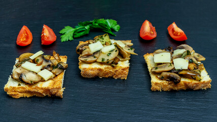 Three slices of toast topped with champignon mushrooms, parsley, emmental cheese and sliced red...