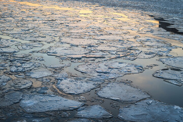 reflection of the sunset in the icy Moscow River.cracked ice on the river. pieces of ice on the river