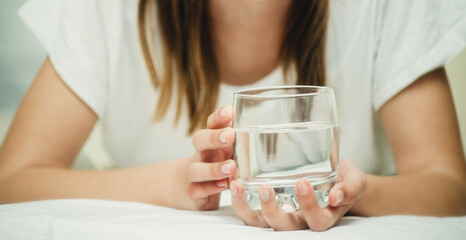 a glass of water in hands close-up