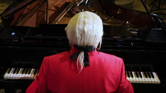 A man pianist, wearing clothes of the 18th century nobility, playing a rondo by Wolfgang Amadeus Mozart on a piano.