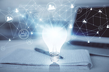 Double exposure of bulb drawing and desk with open notebook background. Concept of idea © peshkova